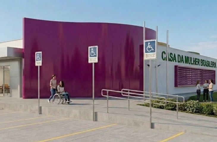 Imagem de uma renderização 3D da entrada principal da "Casa da Mulher Brasileira". Em destaque, uma grande parede curva na cor roxa vibrante. À direita, a fachada branca exibe o nome do local em letras verdes aplicadas. Há rampas de acesso com corrimãos metálicos e placas de sinalização com o símbolo internacional de acessibilidade (cadeirante). Na calçada, uma mulher em uma cadeira de rodas é conduzida por outra mulher. Ao fundo, um grupo de mulheres conversa próximo a uma área de jardim. O ambiente é ensolarado e amplo.