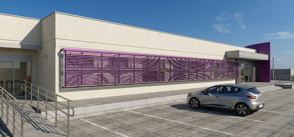 Imagem de uma renderização 3D da lateral externa de um prédio térreo de arquitetura contemporânea. A parede principal é de cor bege clara, com uma janela horizontal extensa protegida por um brise (grade de sombreamento) metálico na cor roxa, com detalhes vazados no centro. À esquerda, há uma rampa de acessibilidade com corrimão metálico duplo. O chão é composto por blocos de concreto cinza, demarcando vagas de estacionamento. Um carro prata está estacionado à direita. O céu está azul e limpo.